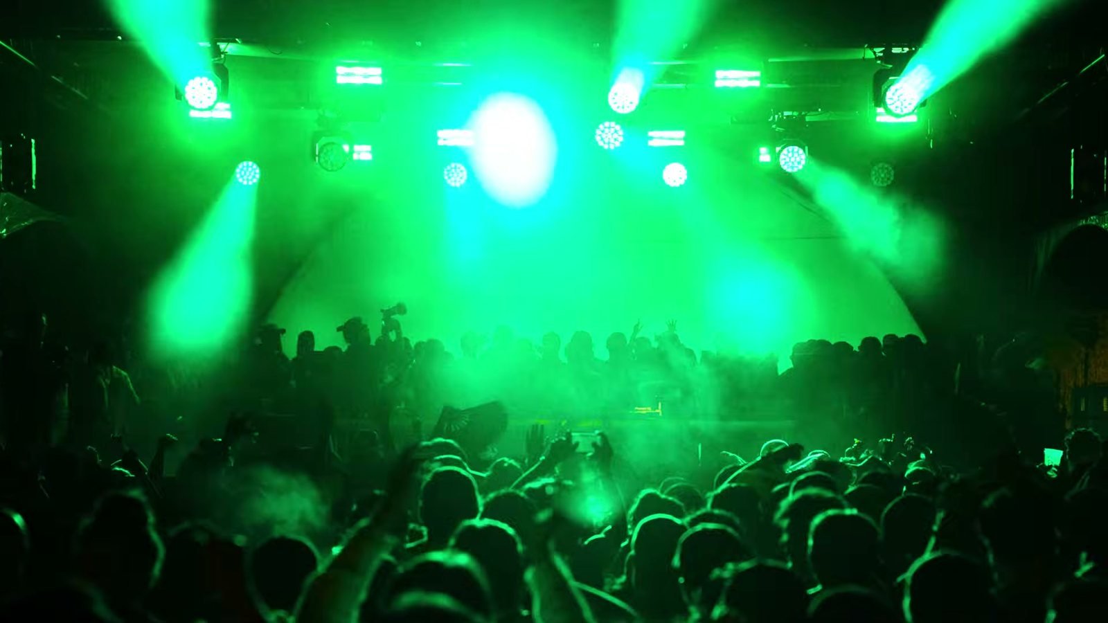 Luces verdes sobre el público en un escenario de noche