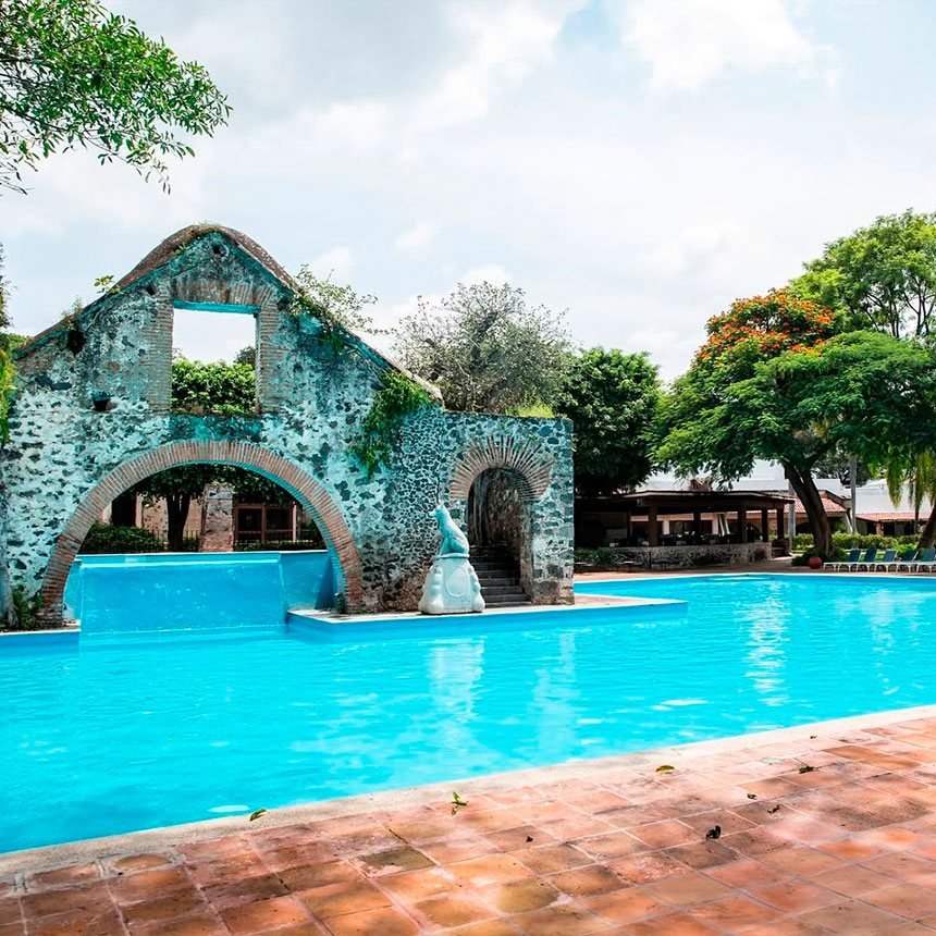 La alberca de Hacienda Cocoyoc frente a un acueducto antiguo de piedra