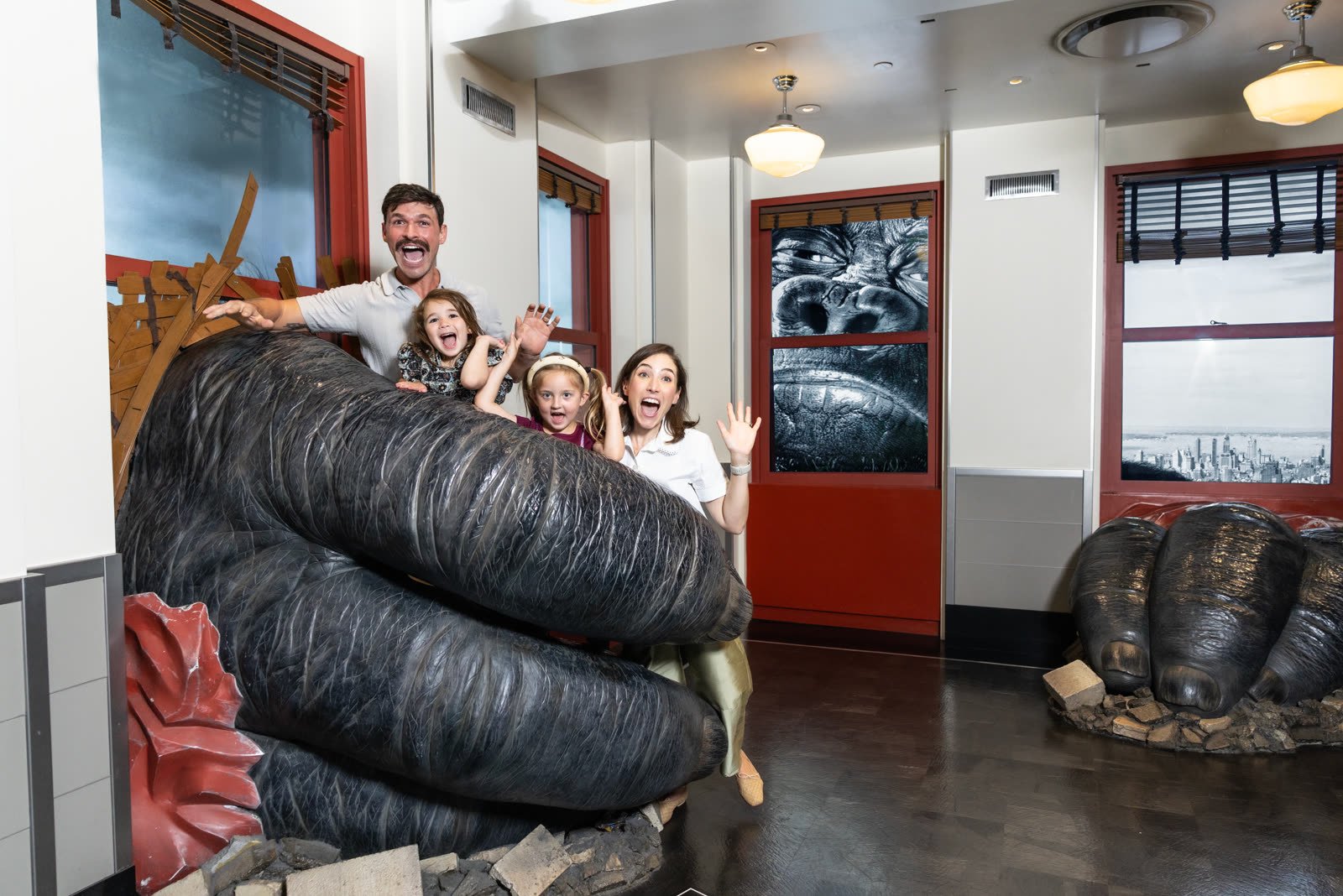 Una familia se trepa a la mano gigante de King Kong que atraviesa la pared