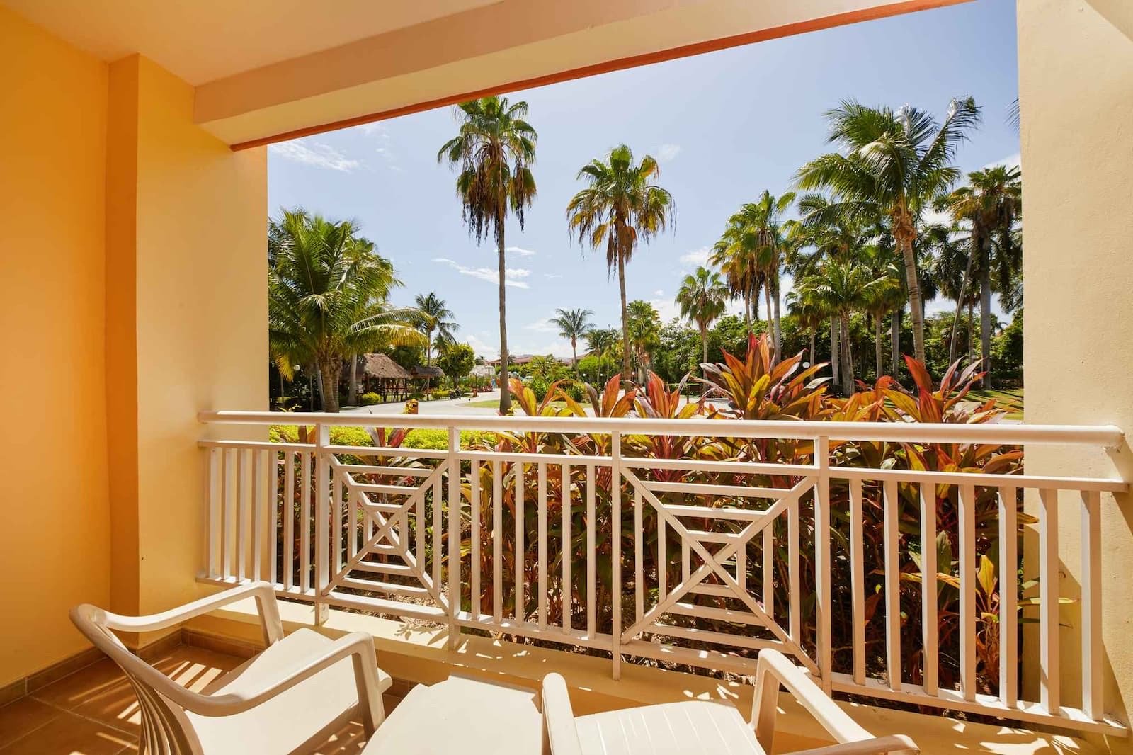 Balcón con sillas y vista a palmeras y jardín