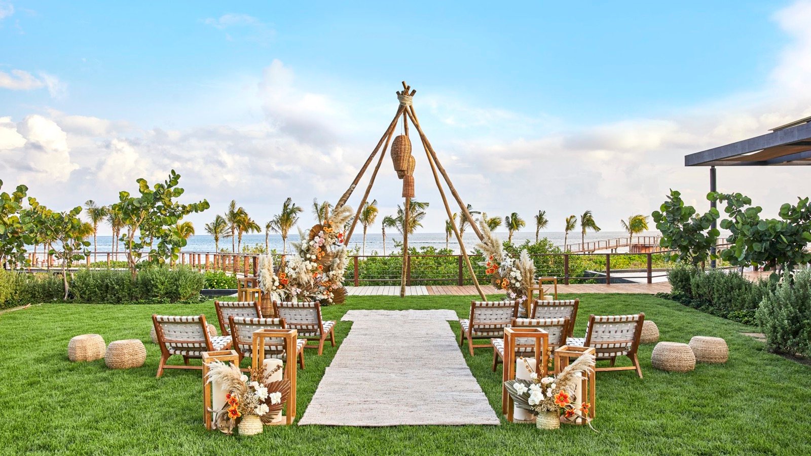 Altar de boda en un jardín frente al mar, con sillas de madera