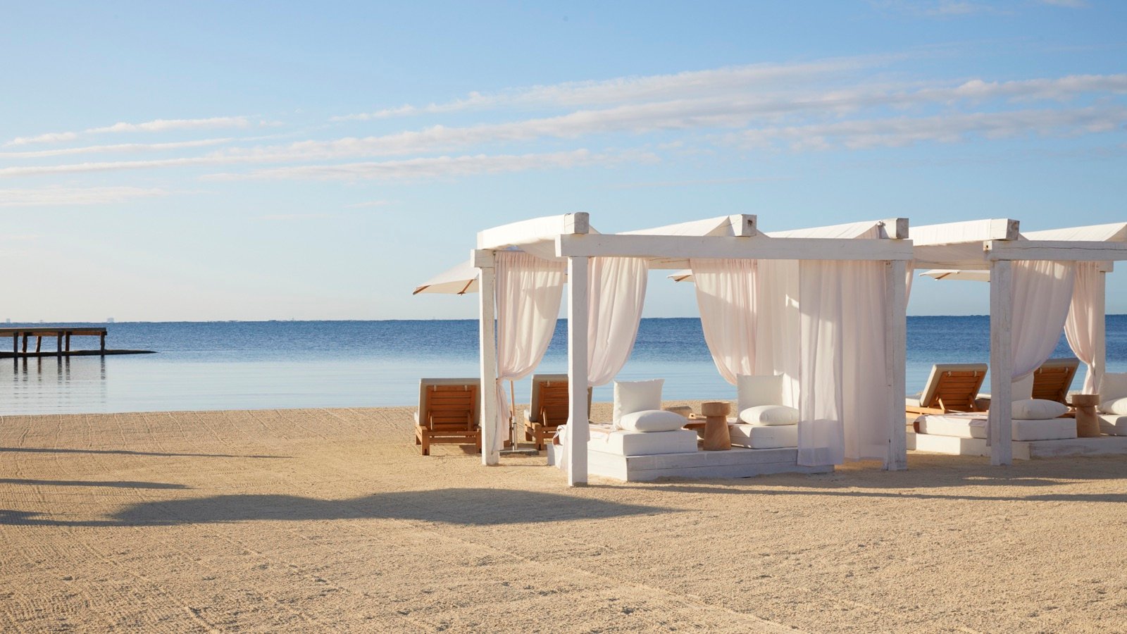 Cabañas blancas con cortinas en la playa