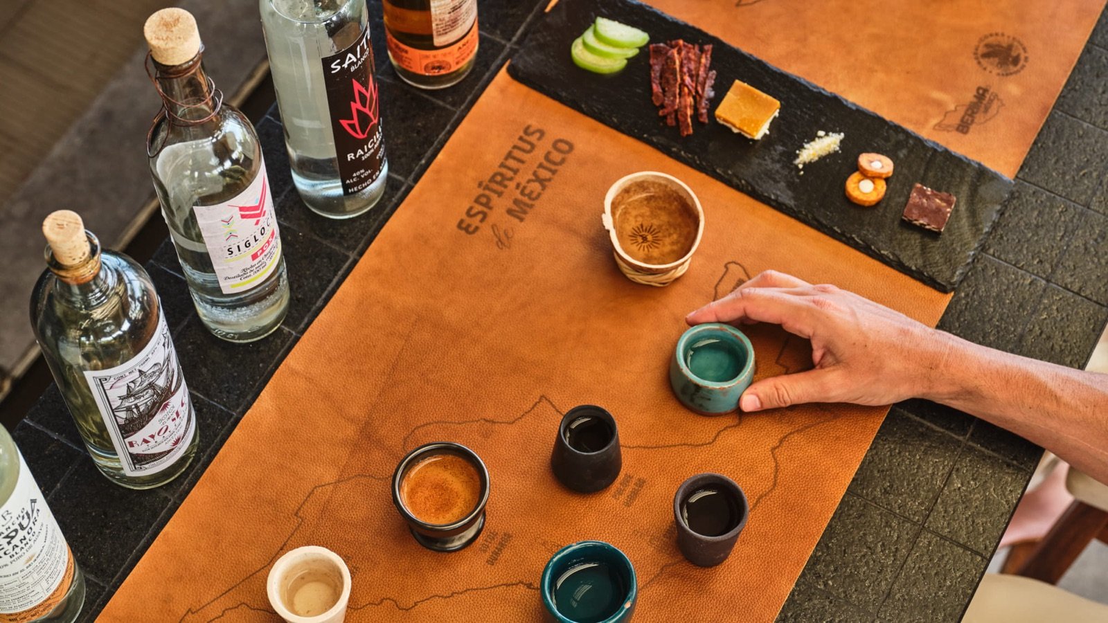 Cata de mezcales en jícaras sobre una mesa de madera