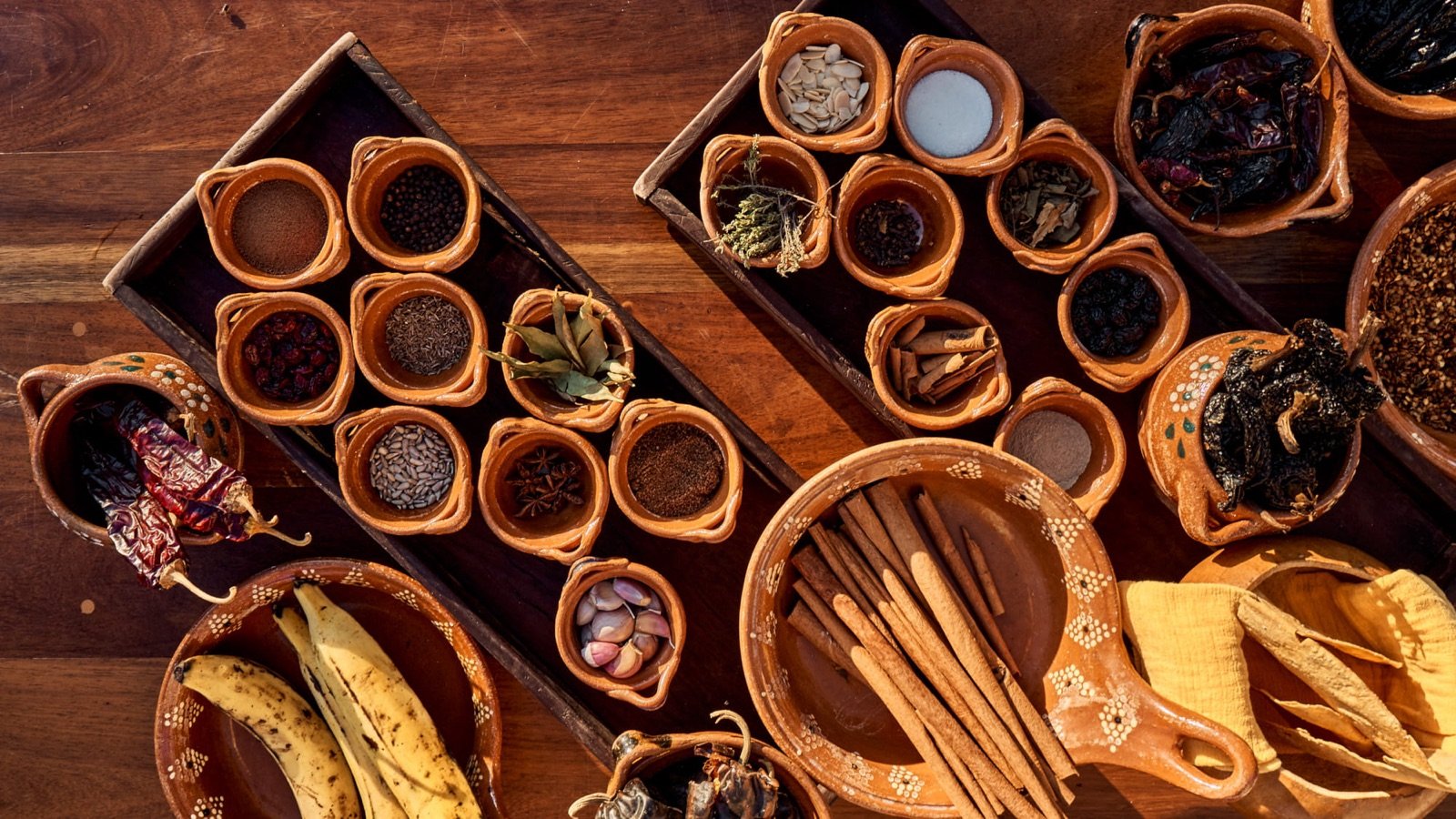 Ingredientes mexicanos en cazuelas de barro: chiles, semillas y especias