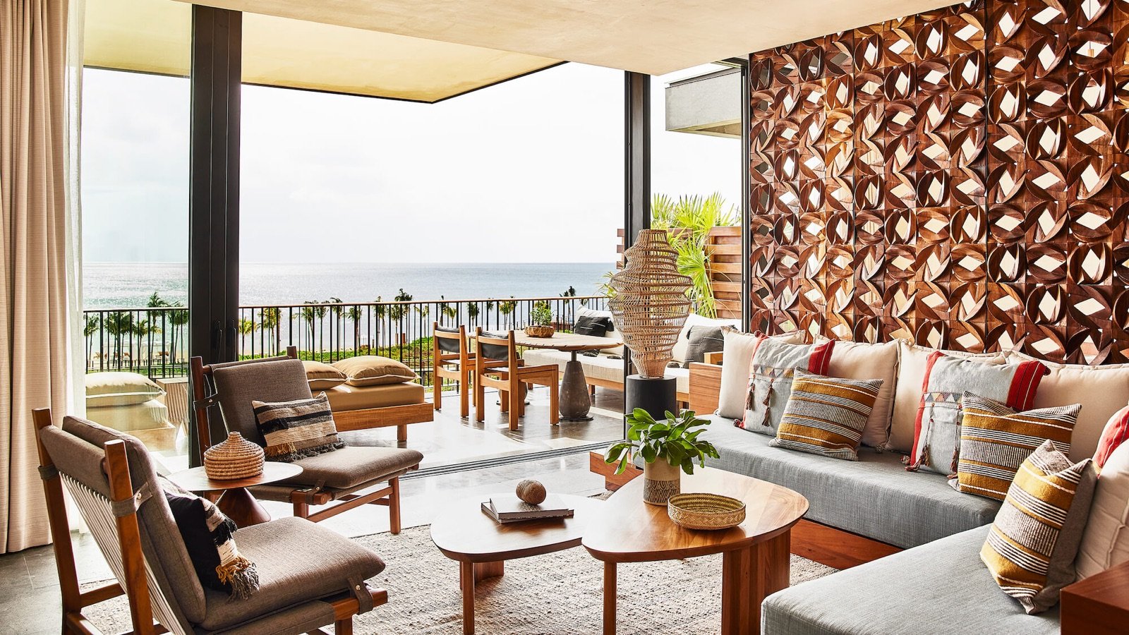 Sala con muro de celosía de piedra y ventanal al jardín
