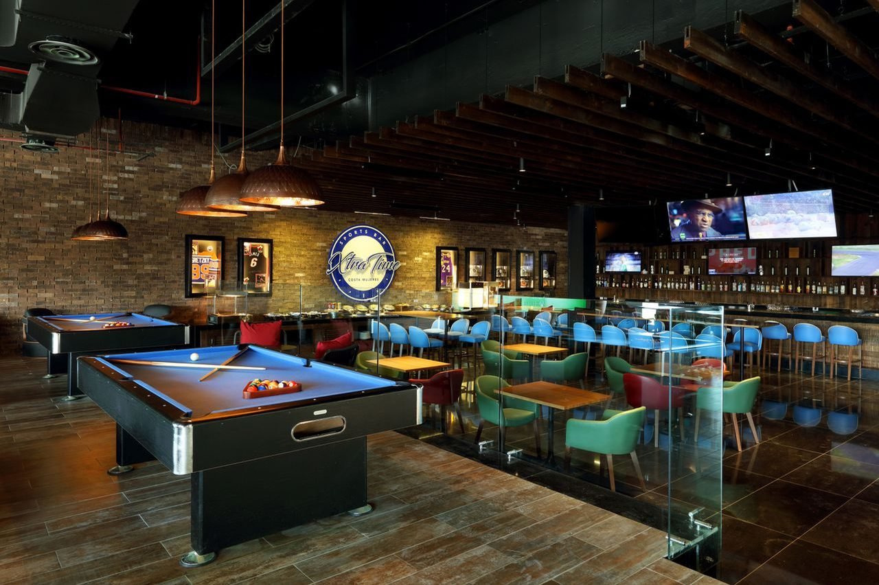 Sports bar con mesas de billar y pantallas