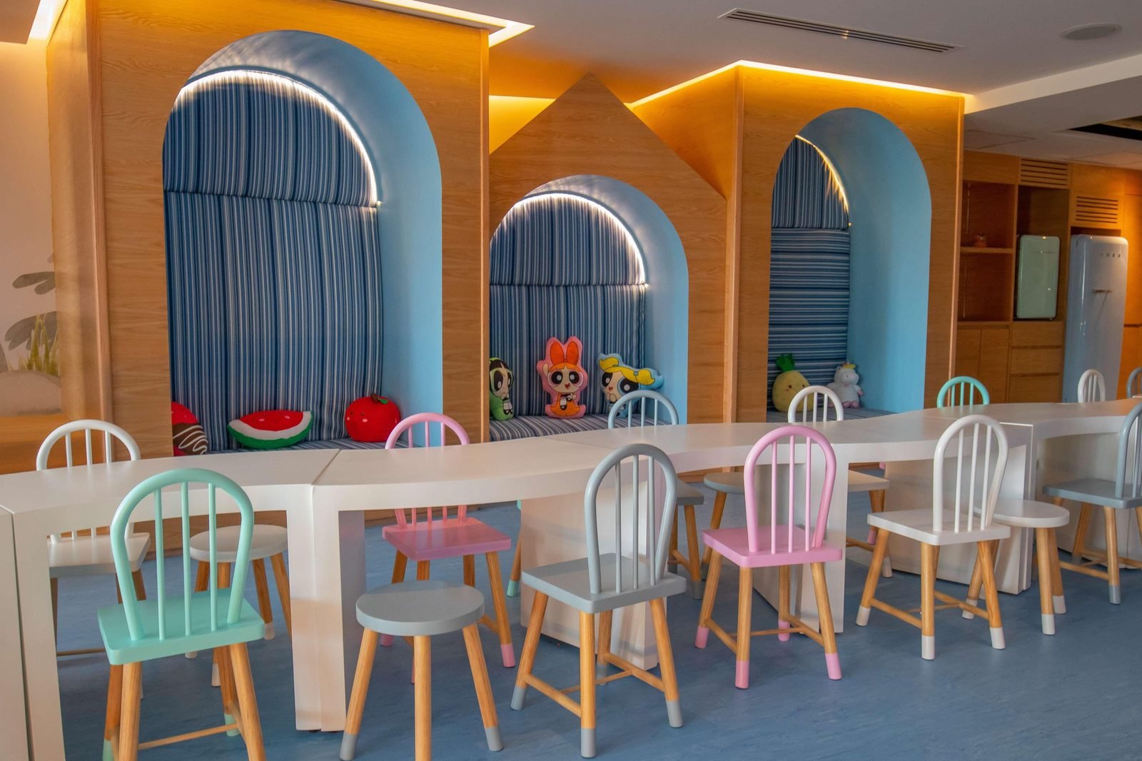 Club de niños con sillas de colores y arcos azules