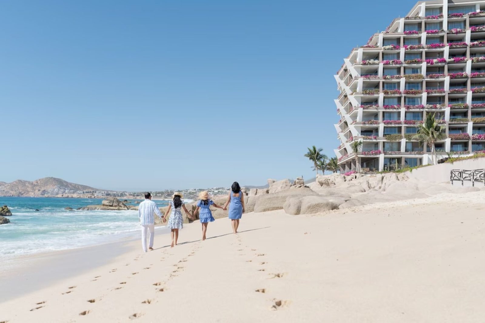 Una familia camina por la playa frente al hotel