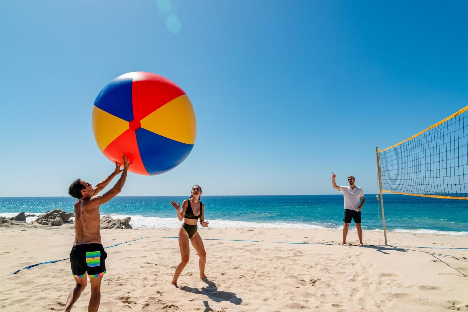 Una familia juega voleibol en la playa