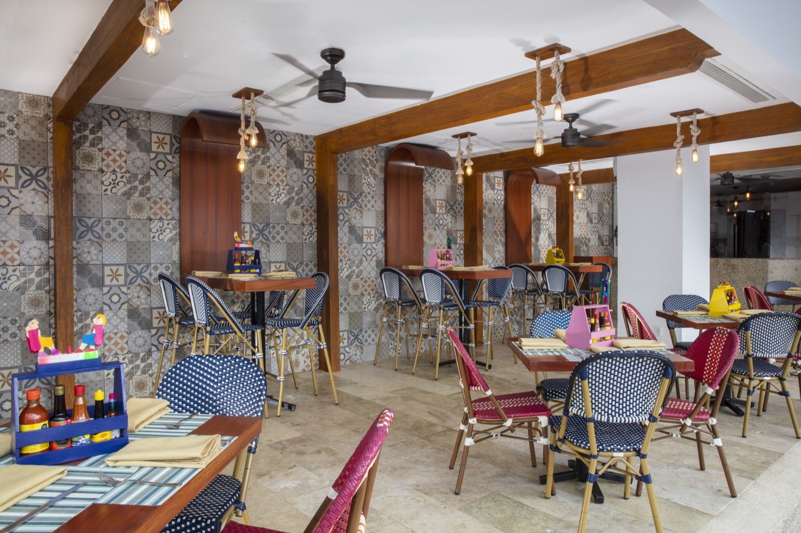 Restaurante con mesas de madera, sillas de colores y barra