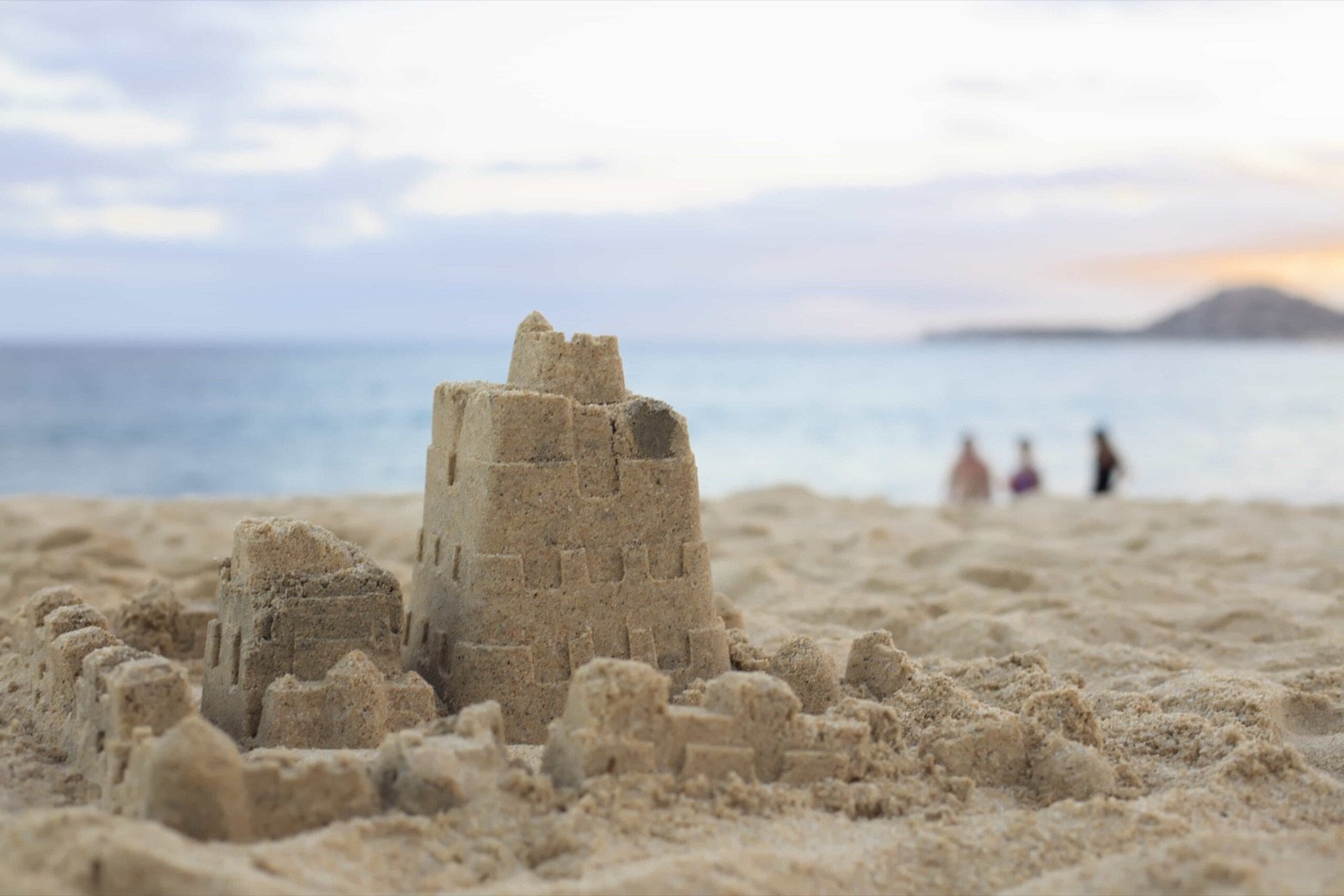 Castillo de arena en la playa frente al mar