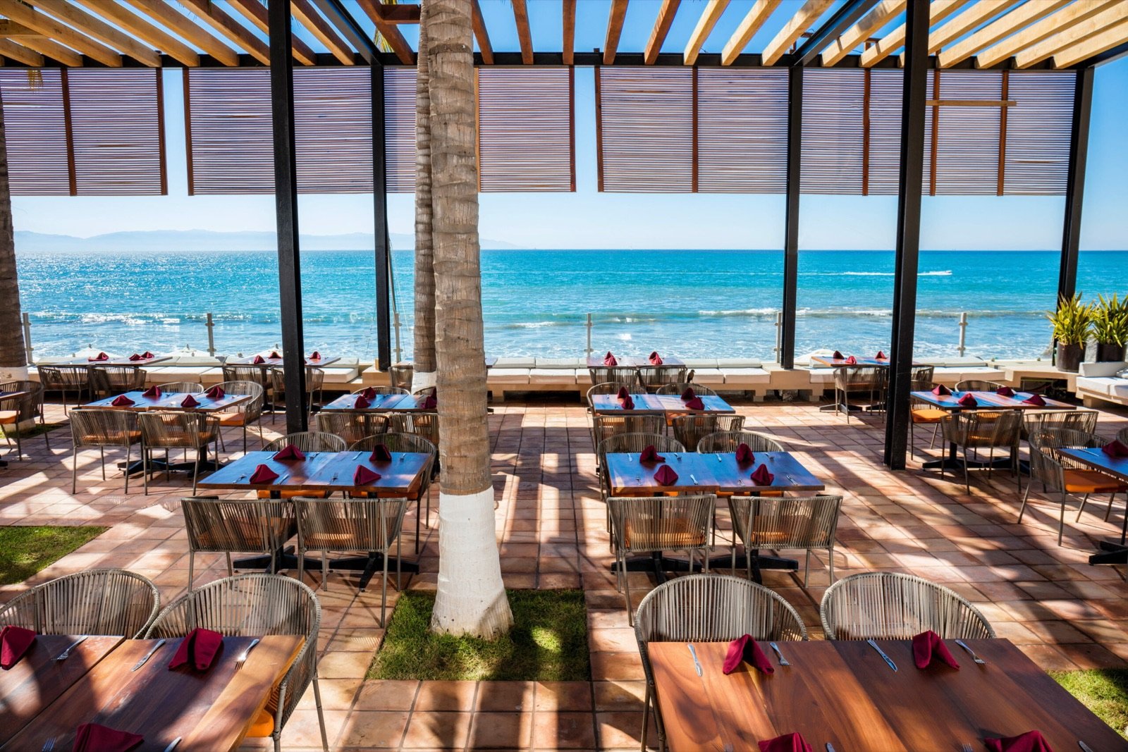 Restaurante al aire libre frente al mar, con techo de madera