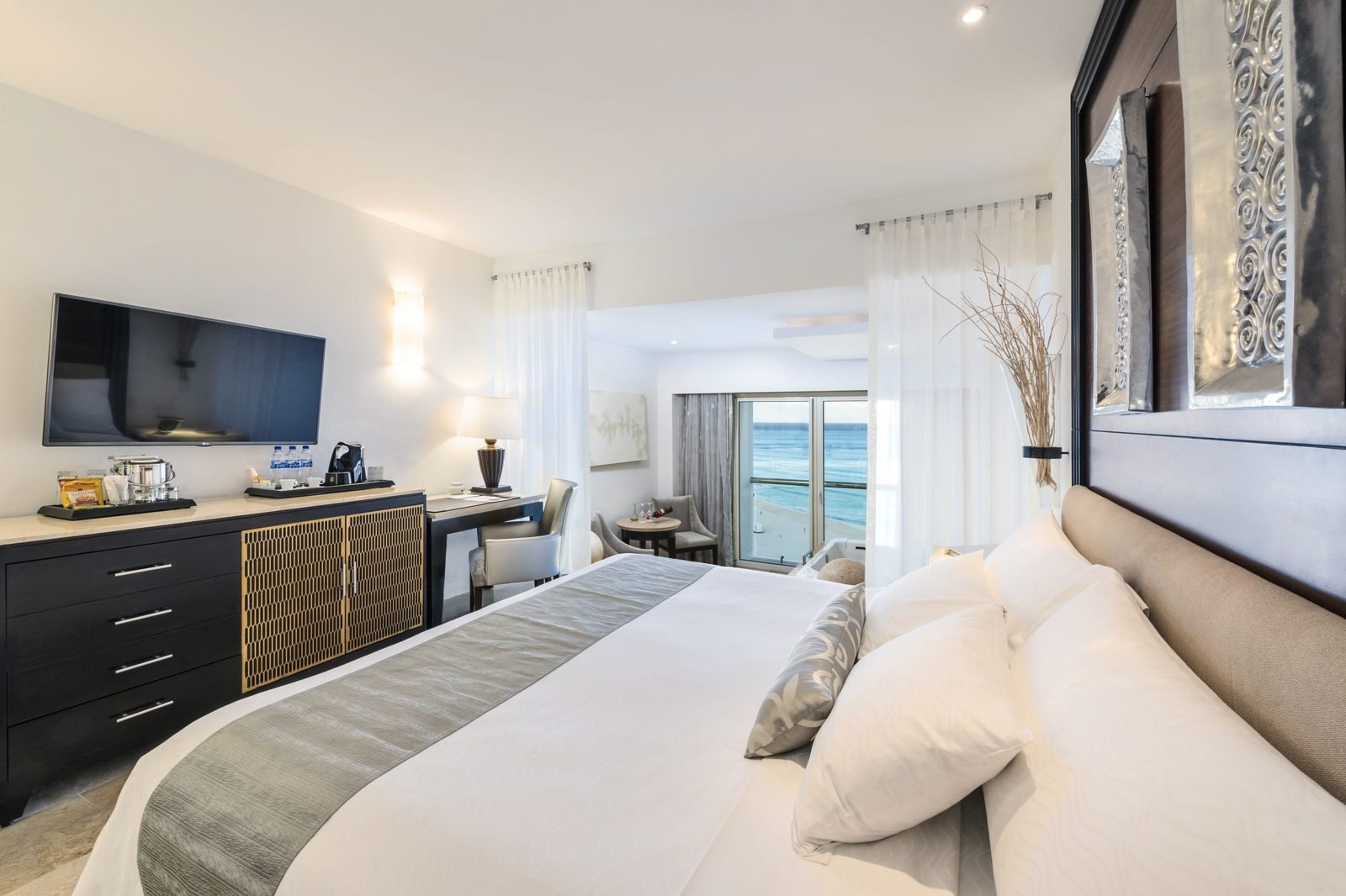 Habitación con cama king, sala y balcón al mar