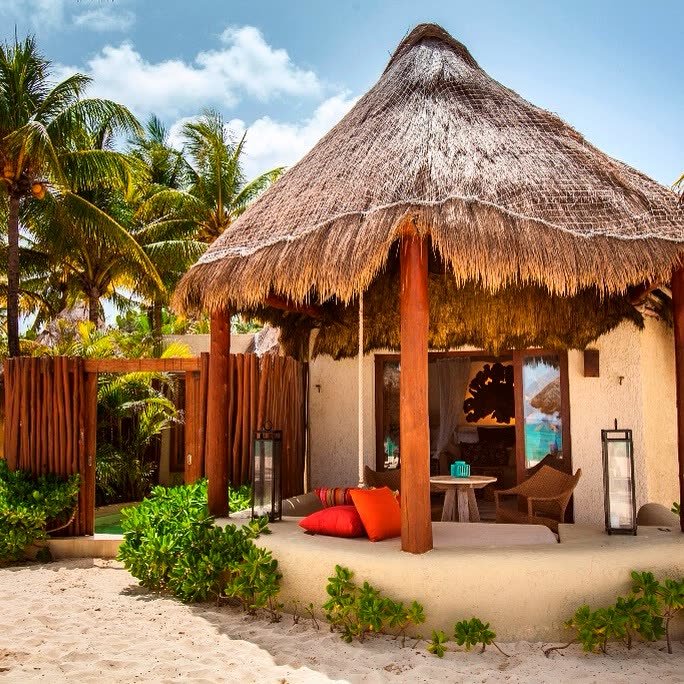 Bungalow con techo de palma frente a la playa