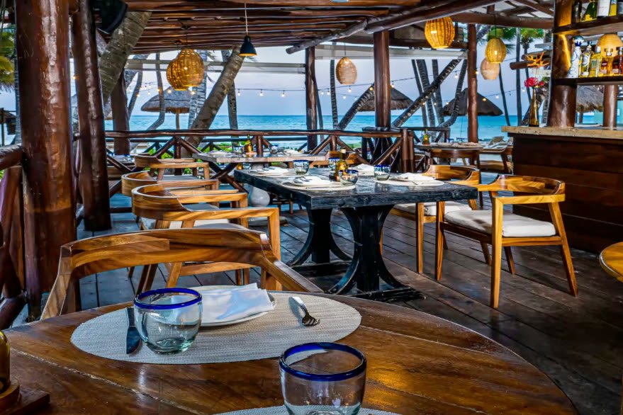Restaurante Fuego con mesas de madera y vista al mar
