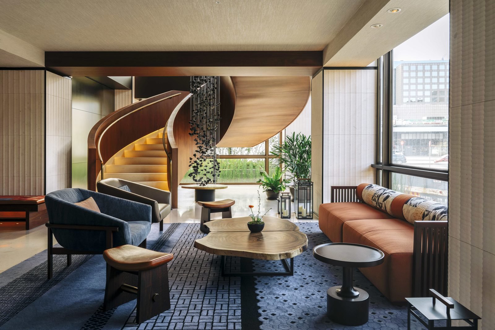 Sala de una suite con escalera de caracol de madera y ventanales