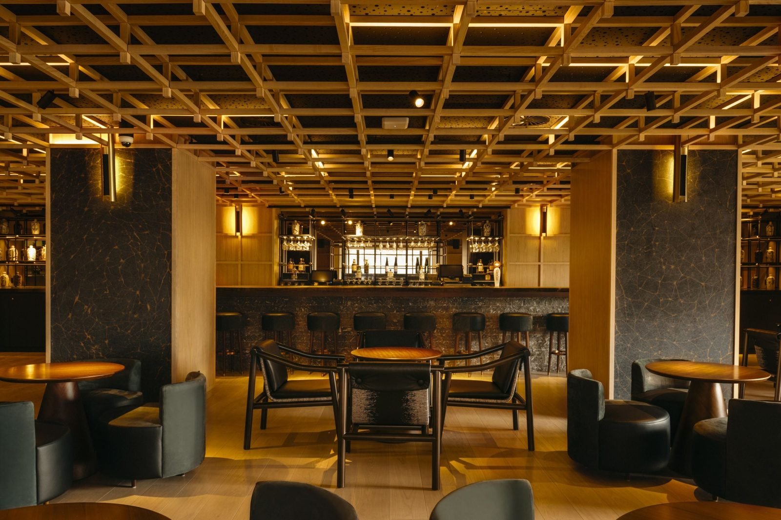 El bar Kozara con techo de vigas de madera y mesas redondas