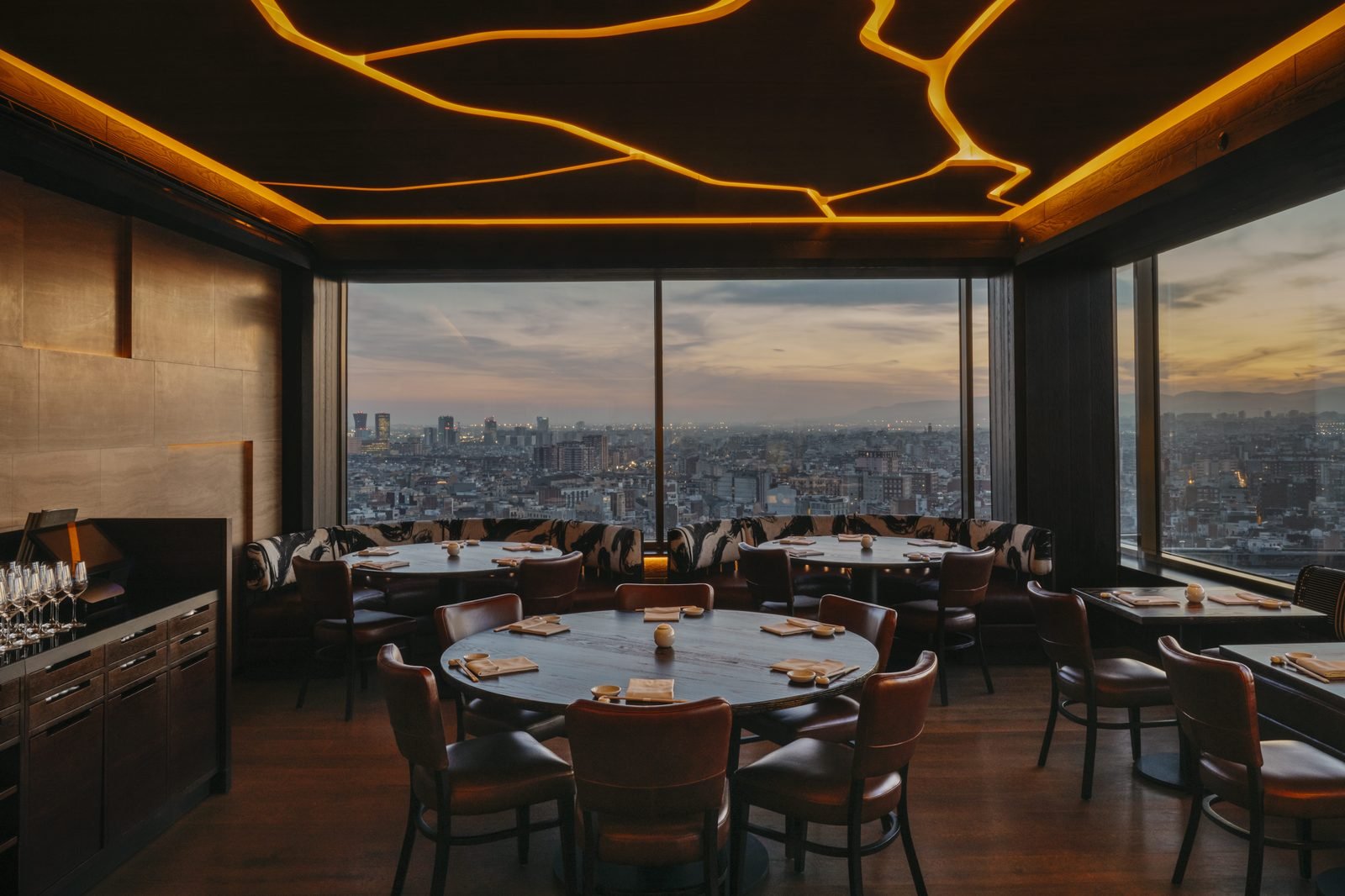 El restaurante Nobu con techo de vetas doradas y ventanales al atardecer