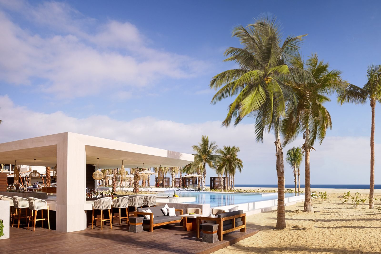 Bar de playa con palmeras y camastros frente al mar