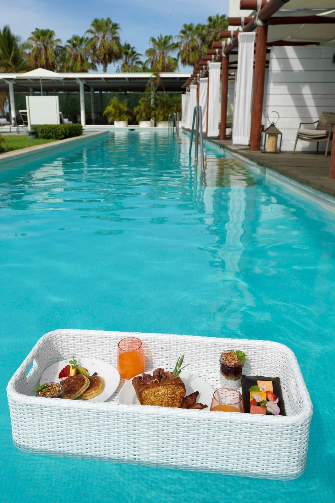 Desayuno en una bandeja flotante dentro de la alberca