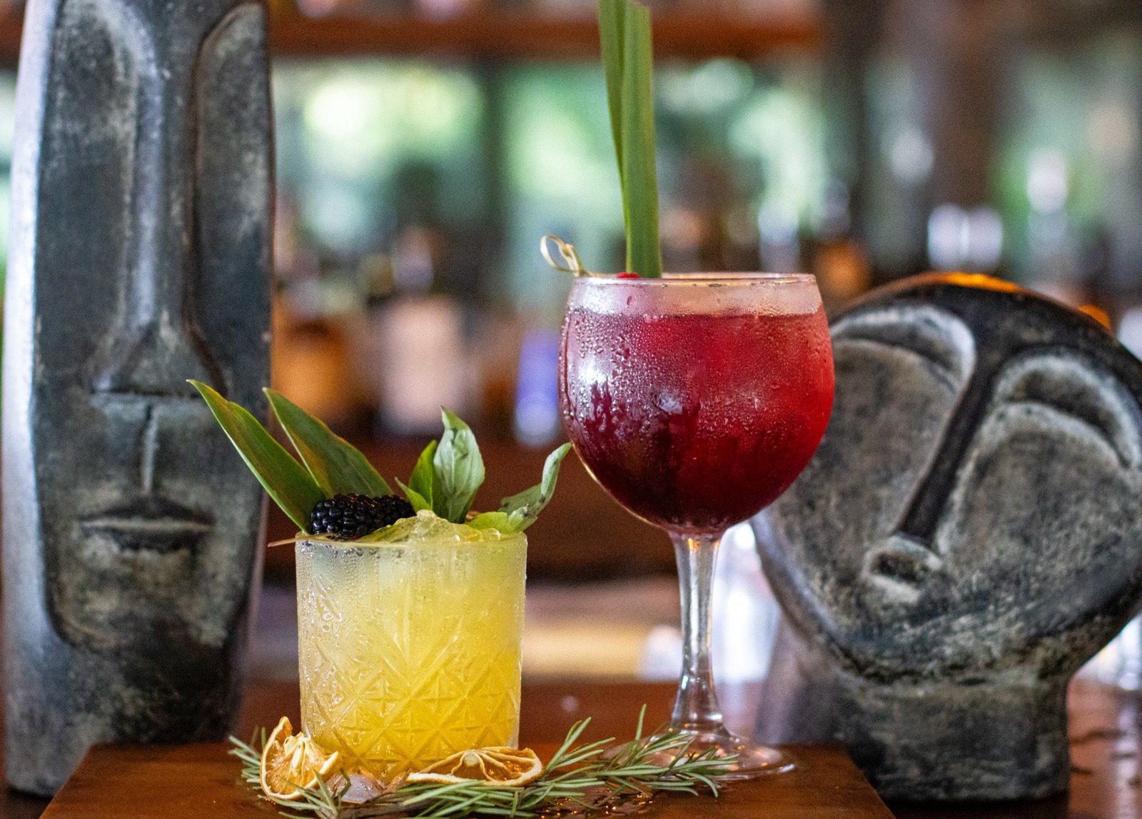 Dos cocteles tropicales en la barra del bar Agua Mala, entre esculturas de piedra