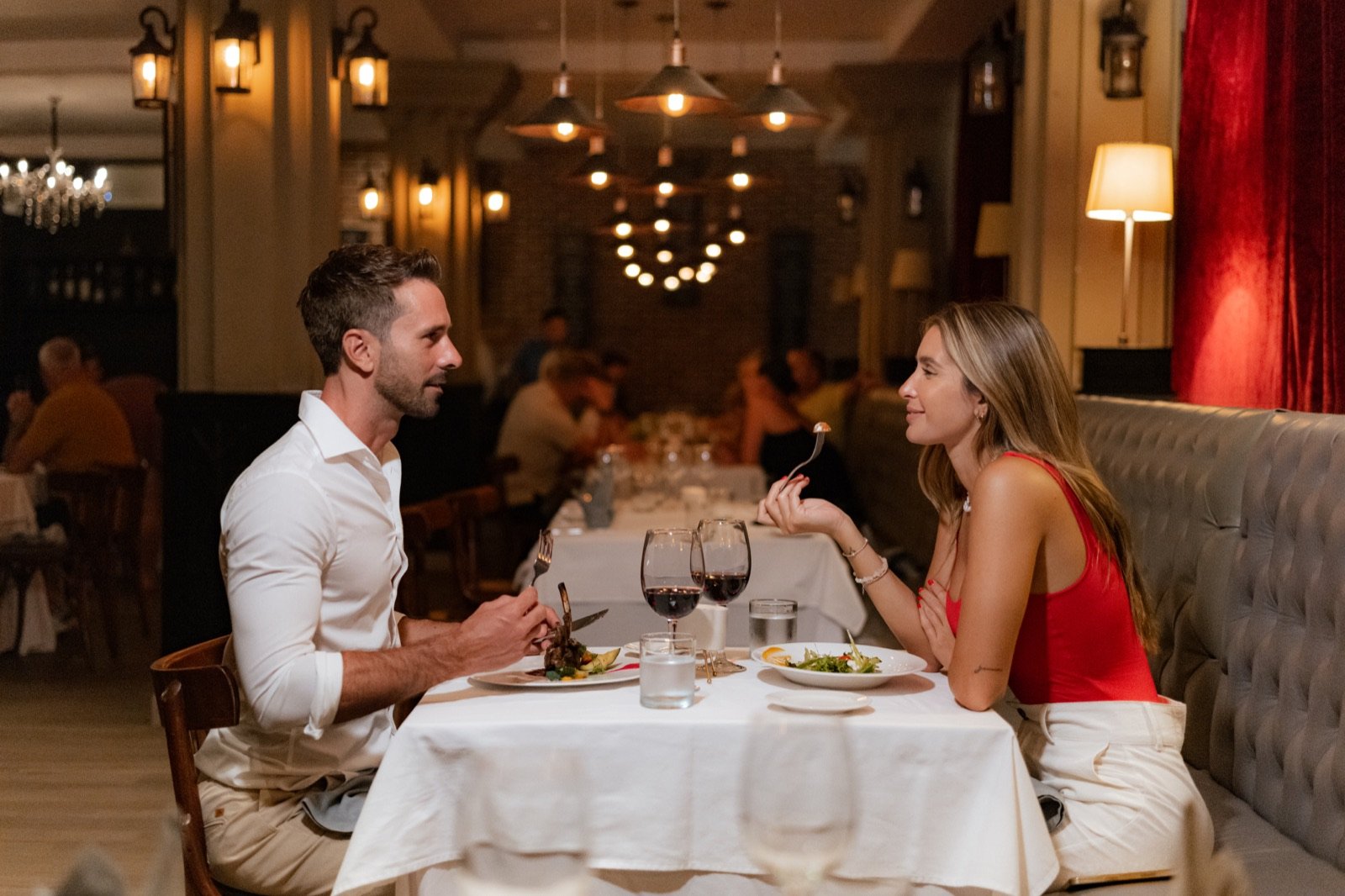 Una pareja cena en La Brasserie, con velas y copas de vino tinto