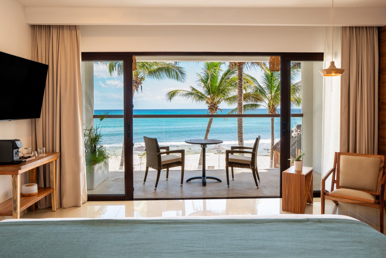 Habitación Beachfront Suite con la cama frente al ventanal y la playa enfrente
