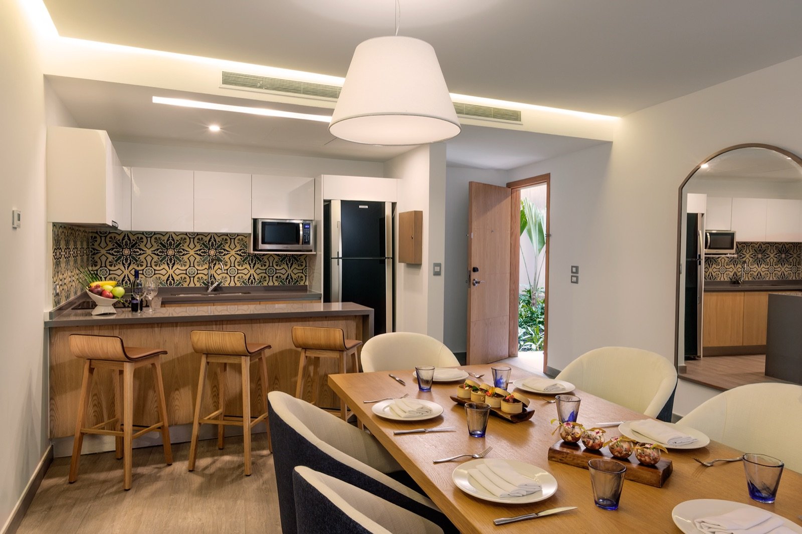 Cocina de una residencia con barra de bancos altos y comedor