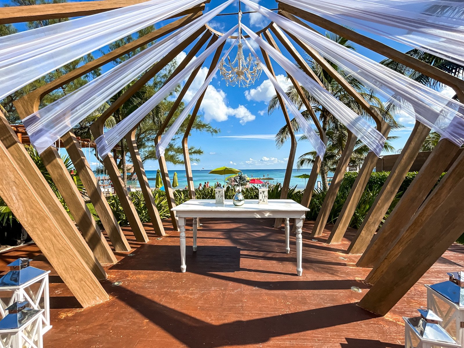 El gazebo de bodas decorado con telas blancas y sillas transparentes