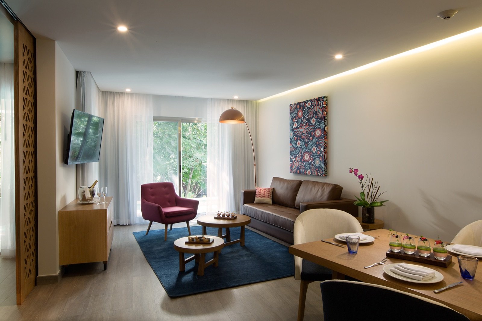 Sala y comedor de una residencia, con tapete azul y luz natural
