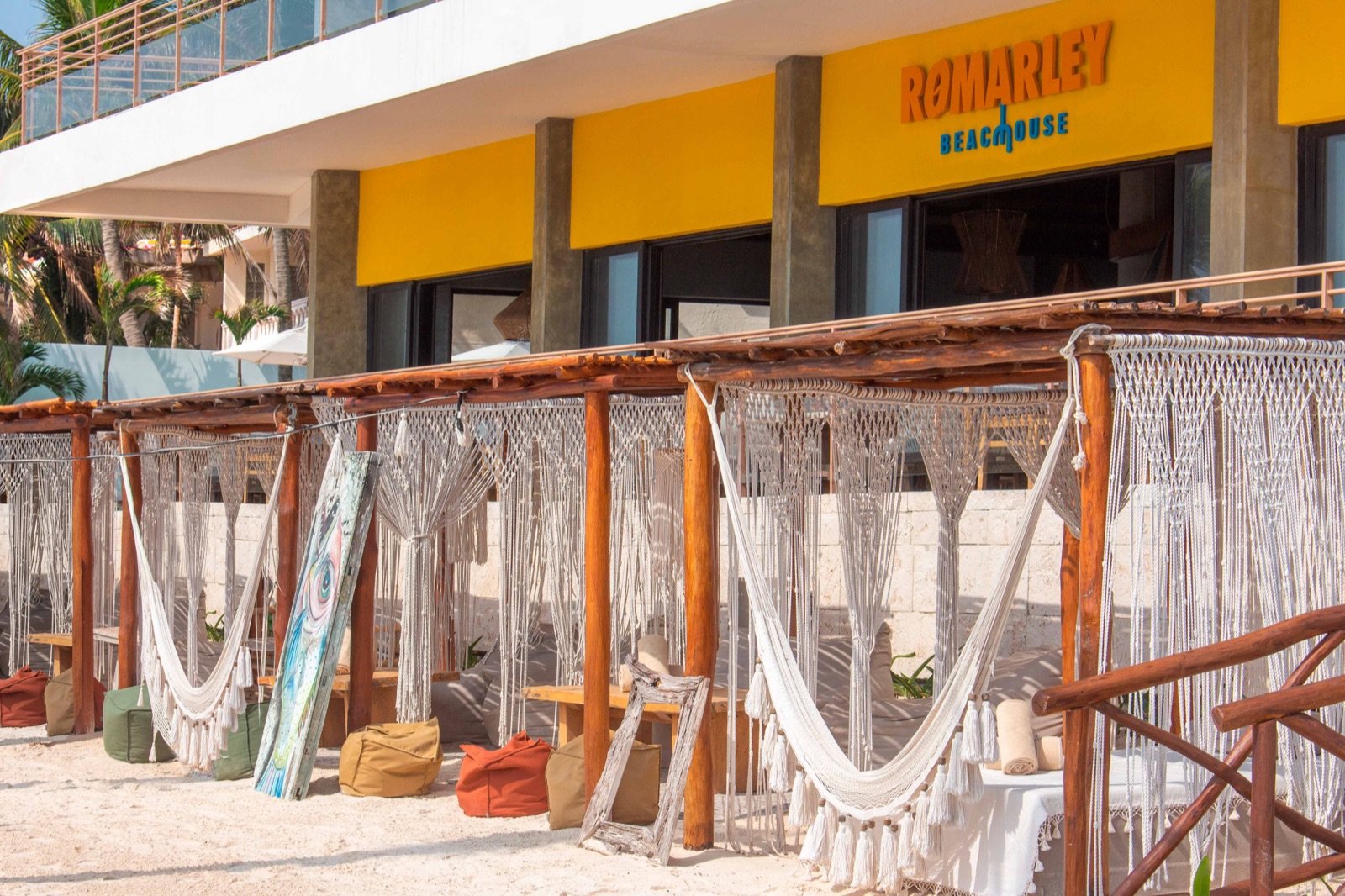 Hamacas y camastros bajo palapas frente a RoMarley Beach House