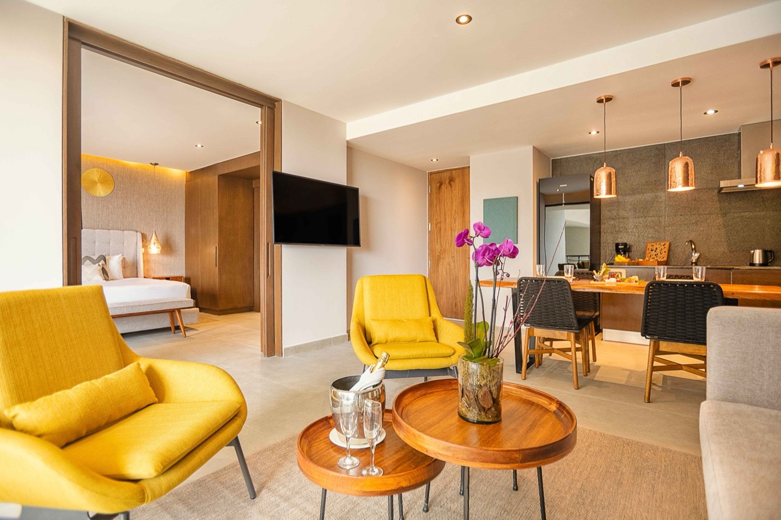 Sala, comedor y cocina de una residencia con sillones amarillos