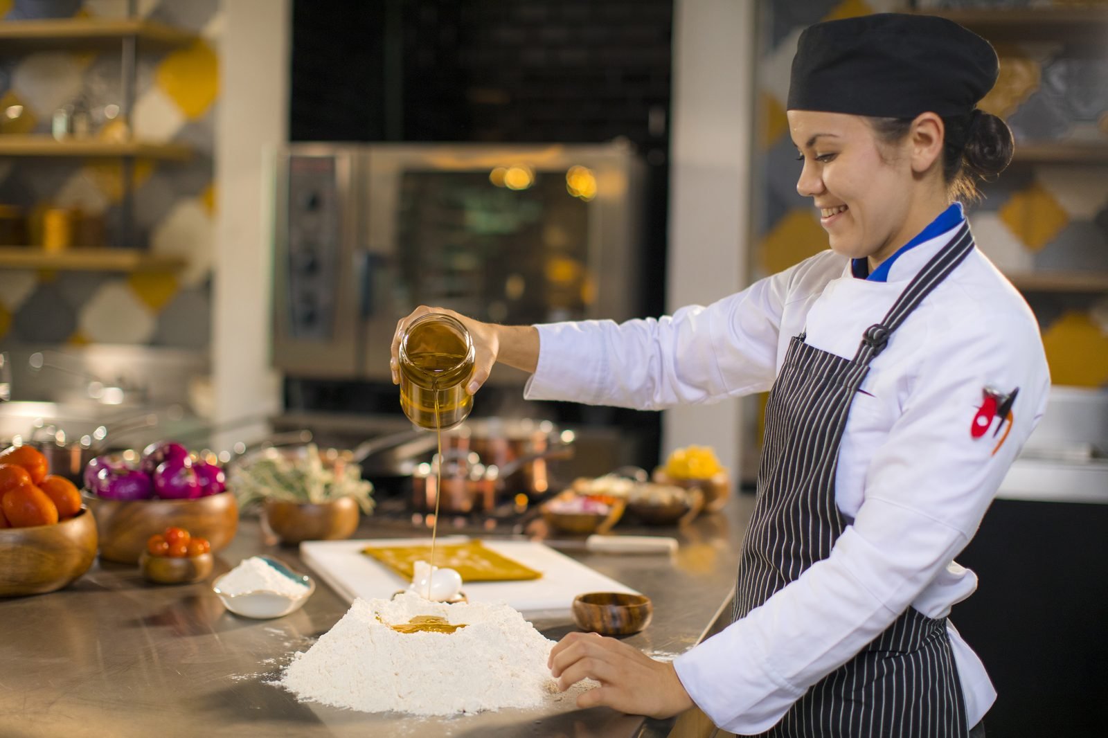 Una chef sirve un platillo en la cocina abierta