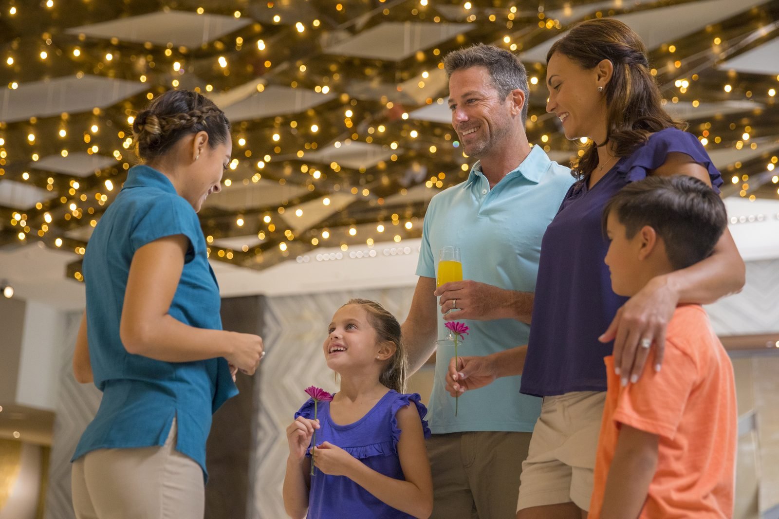 Una familia sonríe en un pasillo iluminado con luces