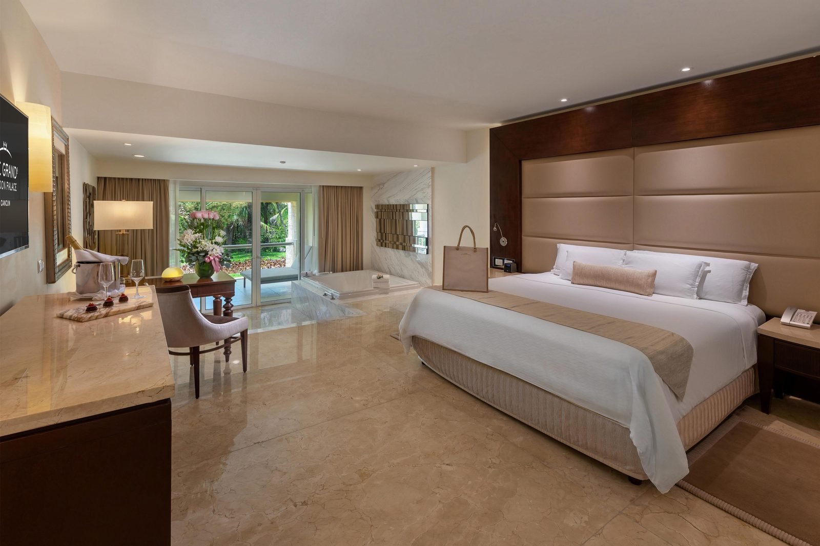 Suite con cama king, sala y ventanal al jardín