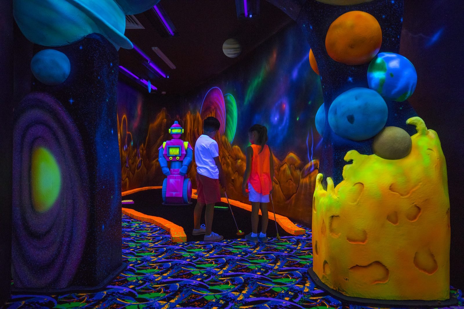 Niños en una sala de juegos con luces de neón