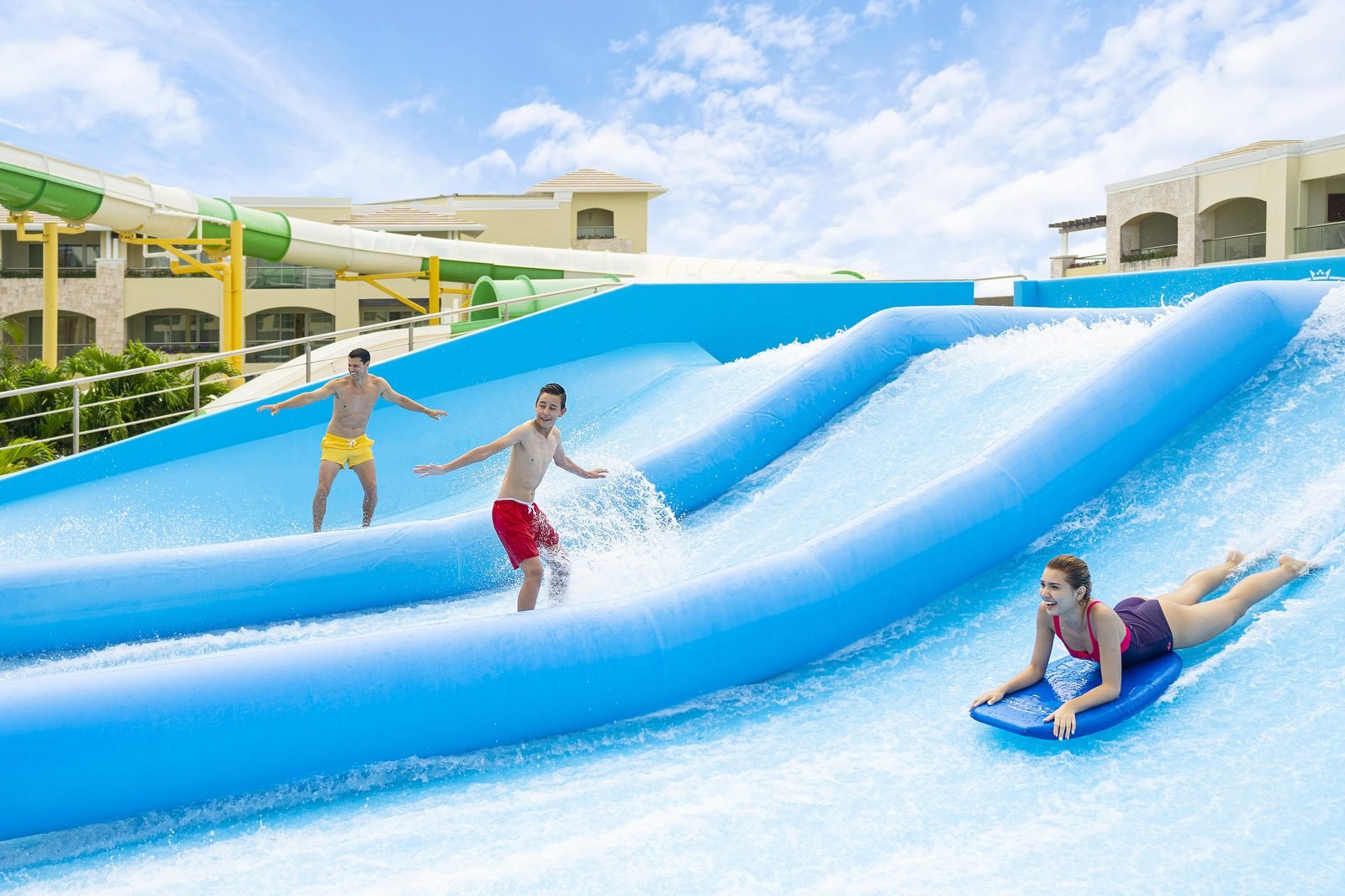 Dos niños surfean en una máquina de olas