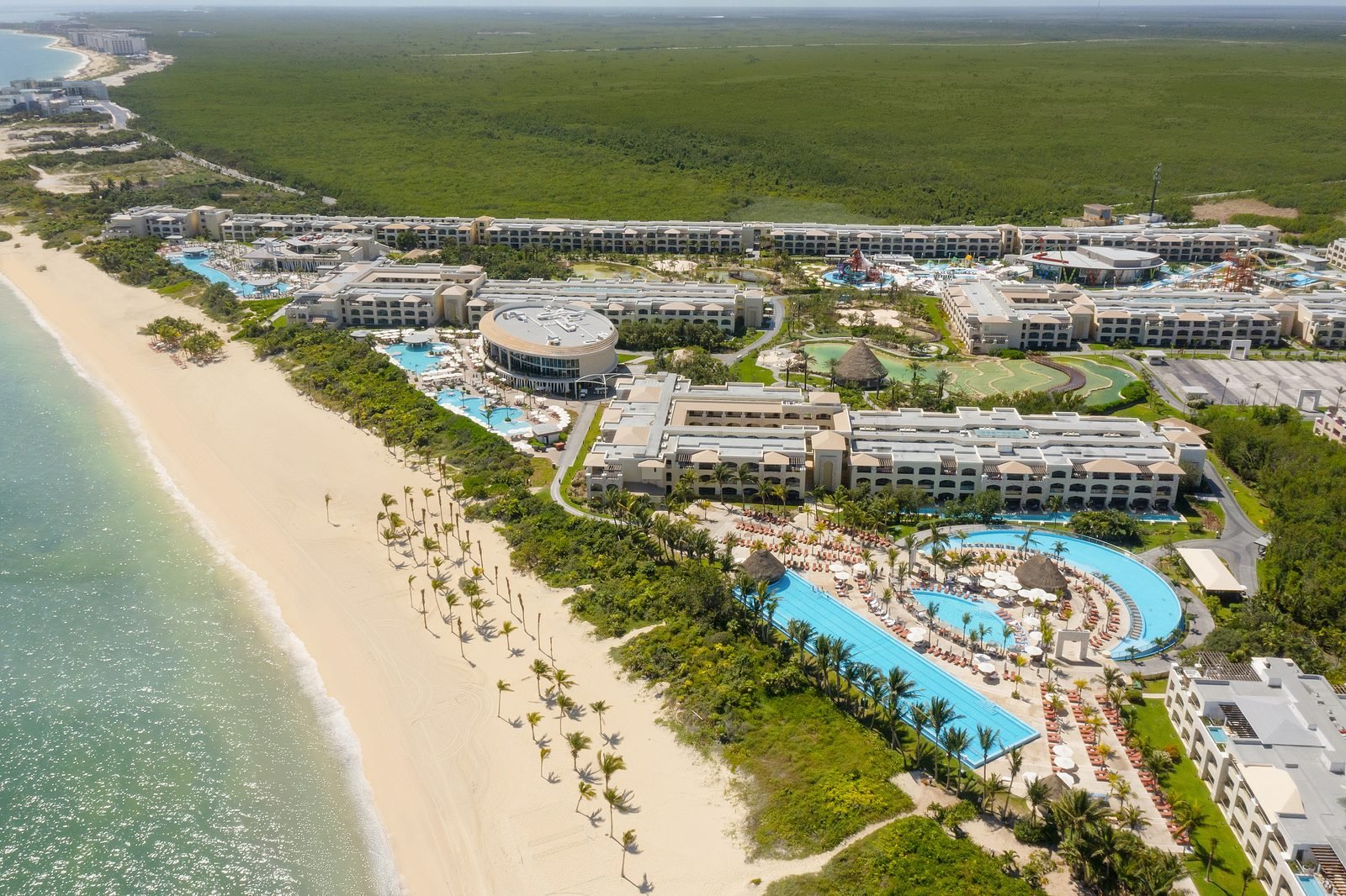 The Grand at Moon Palace desde el aire, con sus albercas y la playa larga junto a la selva