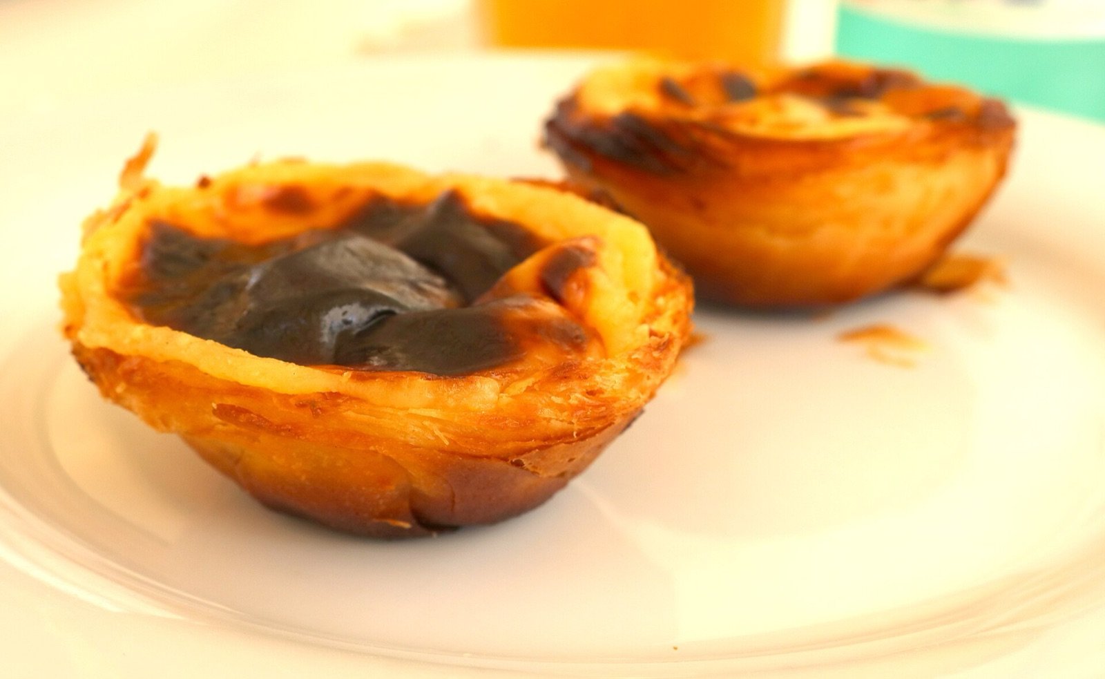 Dos pasteles de nata de Pastéis de Belém con el caramelo tostado encima