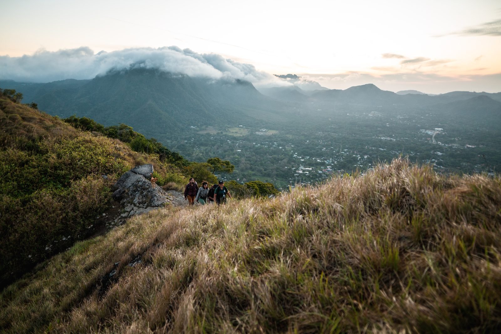 Un grupo contempla El Valle de Antón desde lo alto de La India Dormida, con nubes sobre los cerros