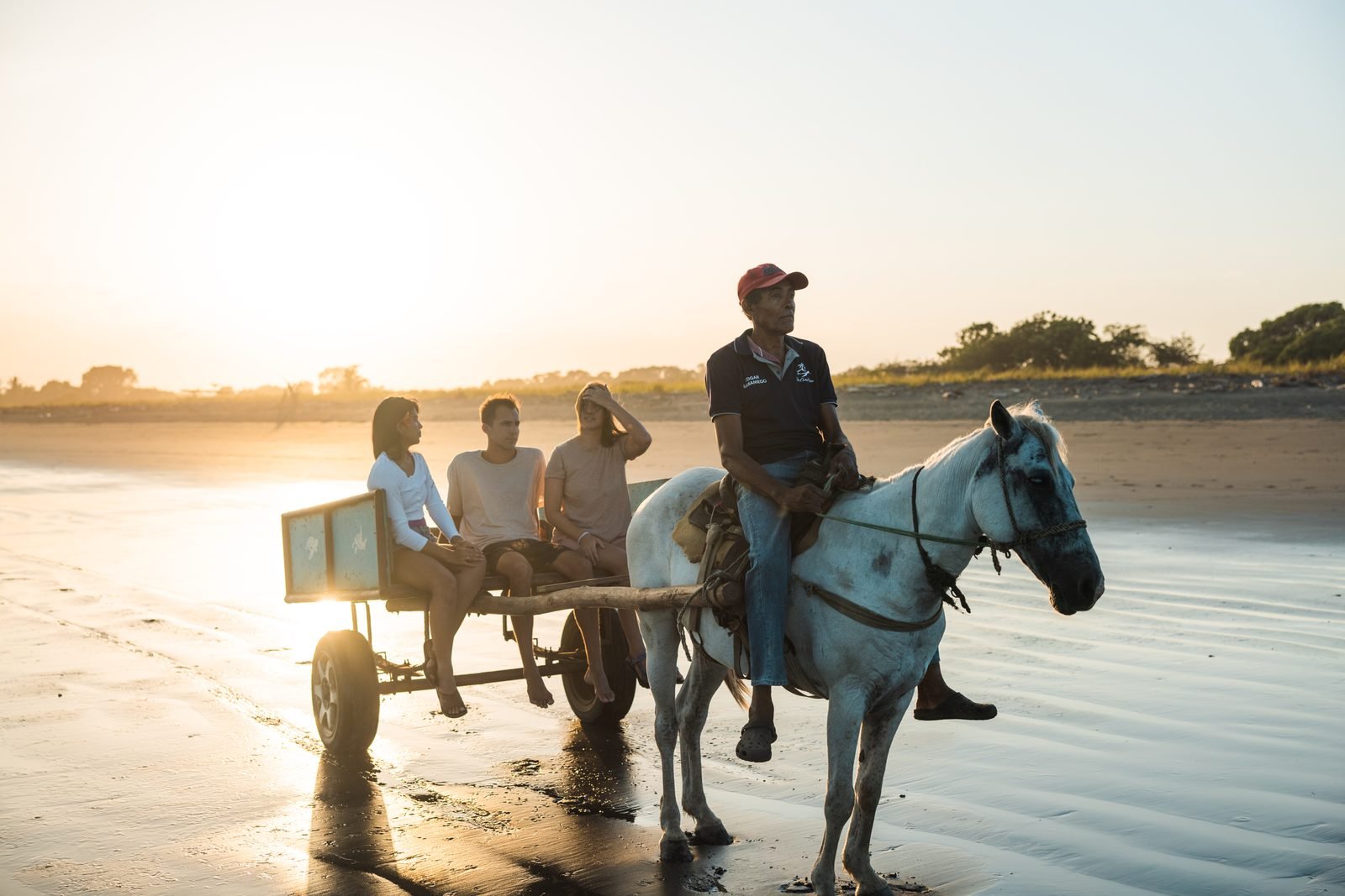 Una carreta jalada por un caballo avanza por la orilla de Isla Cañas al atardecer
