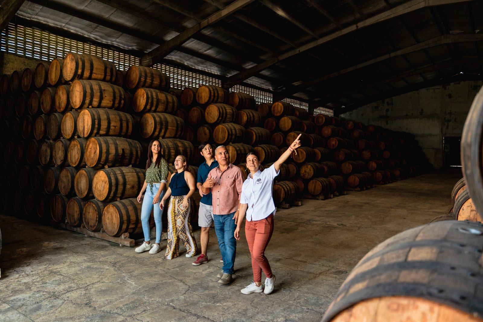 Visitantes recorren la bodega de barricas de ron de la Hacienda San Isidro